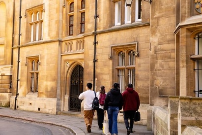 Four students walking through Cambridge